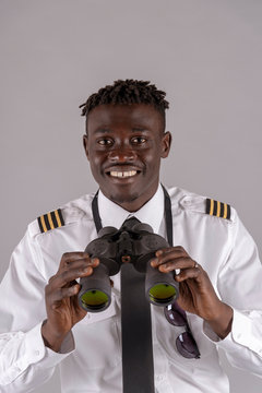 London UK, April 2019.  Young airline pilot using a pair of binoculars.