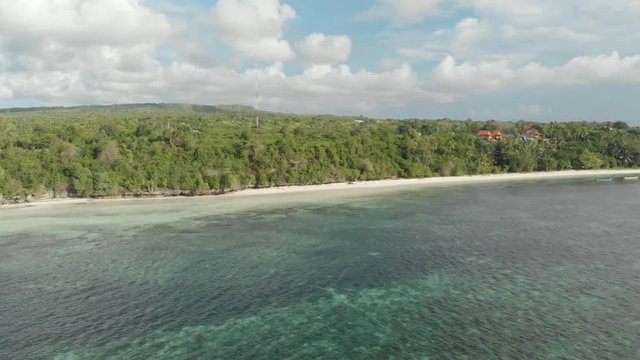 Aerial: Flying over tropical beach turquoise water coral reef , Tomia island Wakatobi National Park Indonesia Maldives Polynesia white sand beach. Native cinelike D-log color profile