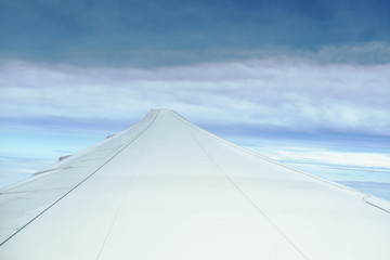 Fototapeta premium plane wing and cloud floating on sky through window frame
