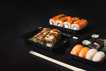 Various kinds of sushi served on black background