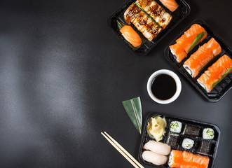Various kinds of sushi served on black background