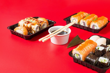 Various kinds of sushi served on red background