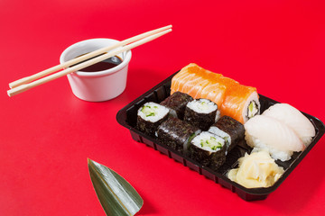 Sushi rolls set served on red background.