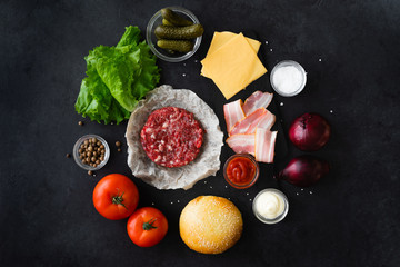 Top view and flat lay of burger ingredients and sauce on black table with copyspace. Burger food...