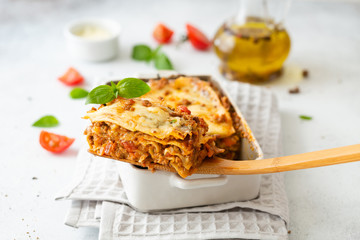 Tasty lasagne with meat, cheese on white plate