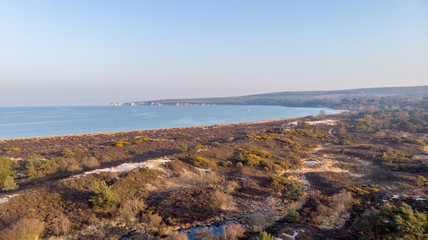 Fototapeta na wymiar An aerial view of the Studland Nature Reserve with sand dune, peat bog, sea and white cliff in the background under a majestic blue sky
