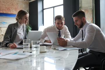 Three young businessmen discussing business at an office meeting.