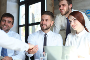 Welcome to our team. Young modern businessmen shaking hands while working in the creative office.