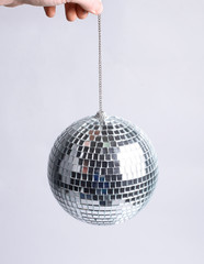 closeup. hand holding a mirror ball.isolated on gray background