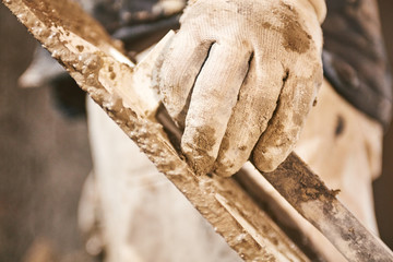 Real construction worker making a wall inside the new house.