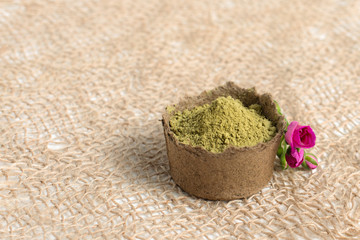 henna powder for dyeing hair and eyebrows and drawing mehendi on hands,  with green palm leaf