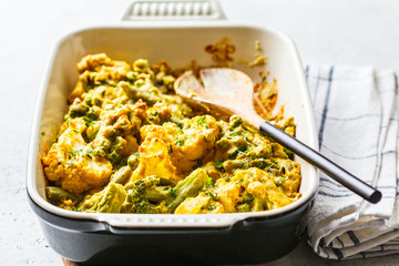 Broccoli, green peas and cauliflower cheese casserole in the oven dish.