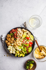 Vegetarian lunch. Brown rice with mushrooms, beans, salad and hummus in black plate, clean eatind.
