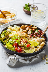 Vegetarian lunch. Brown rice with mushrooms, beans, salad and hummus in black plate, clean eatind.