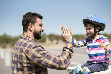 Padre e hijo chocan las manos tras disfrutar de una mañana de bicicleta