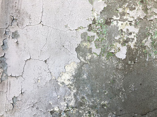 Old dirty grey concrete wall with cracked and peeling paint.