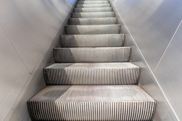 Empty electric escalators going up, stainless steel finishings, closeup view