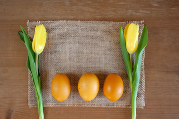 Jajka barwione kurkumą otoczone żółtymi tulipanami
