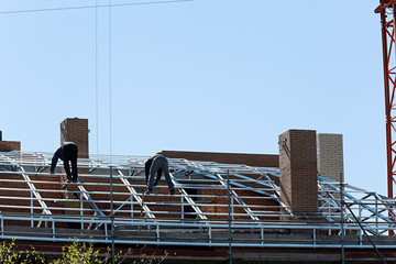 Obreros trabajando en la construcción de un tejado.