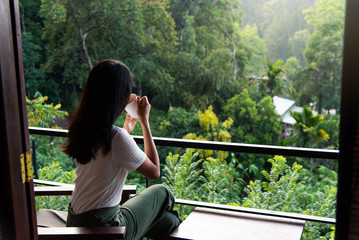 Woman having a cup of tea on the balcony