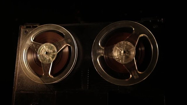 Old vintage reel to reel player and recorder on dark toned foggy background. Analog Stereo Open Reel Tape Deck Recorder Player with Reels. Selective focus