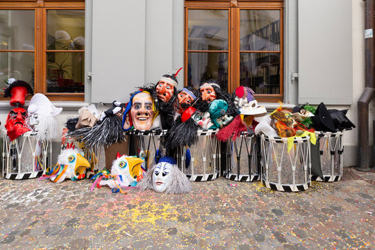 Augustinergasse, Basel, Switzerland - March 12th, 2019. Carnival masks and snare drums piled up in a street corner