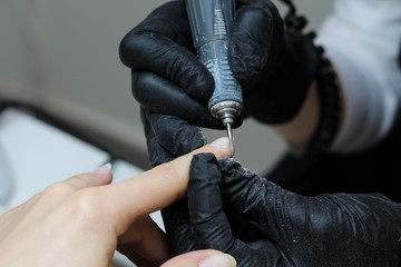Hands in gloves cares about hands nails. Manicure beauty salon. Nails filing with file.