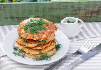 Delicious pancakes from courgettes and fresh vegetables with sour cream and dill
