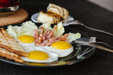 fried  soft-boiled eggs with ham sprinkled with greens and spices with toast and tea, Classic English breakfast