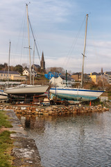Fototapeta na wymiar Boats in Clifden bay pier with village in background