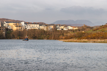Boat in Clifden bay with village in background
