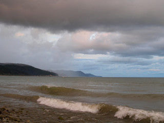 Seascape in a storm at sea with a ship. Summer. Cloudy day