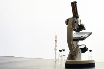 Research laboratory. Test tubes and microscope on the table on a white background.