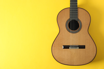 Obraz premium Beautiful classic guitar on yellow background, space for text