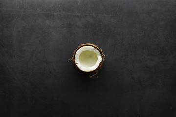 Coconut on a dark stone table. Coconut oil.
