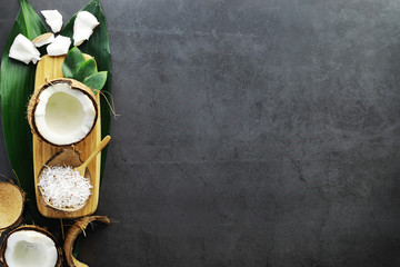 Obraz na płótnie Canvas Coconut on a dark stone table. Coconut oil.