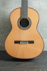 Beautiful six - string classic guitar on wooden table against grey background