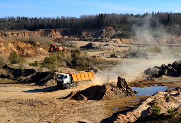 Mining dump truck transports sand and other minerals in the quarry.