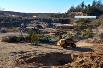 Big yellow mining truck transporting sand in an open-pit mining quarry, top view - image