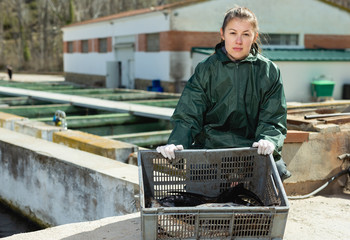 Proud female fish farm owner with sturgeons
