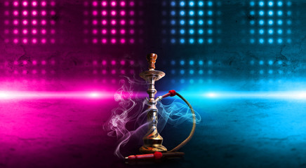 Hookah smoking on a dark abstract background. Background of empty scenes with neon lights and...