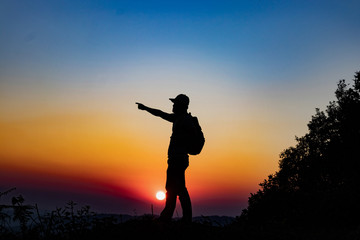 Fototapeta na wymiar silhouette man on top mountain in sunset