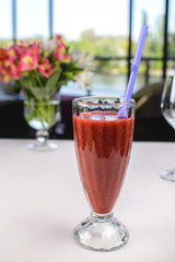 cocktail with strawberries, mint and ice in a glass tumbler