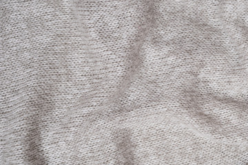 Texture of a gray wool knitted sweater. Close-up. Folds