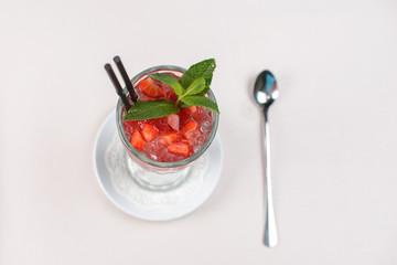 cocktail with strawberries, mint and ice in a glass tumbler