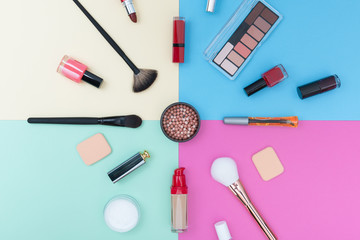 Decorative cosmetics, makeup products and brushes on pastel color background