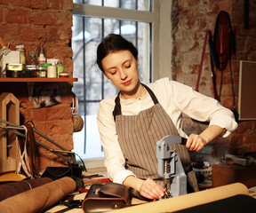 Leather handbag craftswoman at work in a workshop