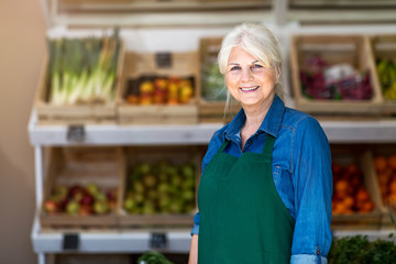Senior woman working in small grocery store