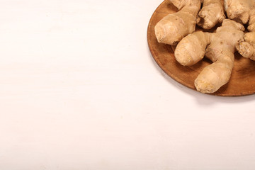 Healthy ginger root on cutting board and knife. Isolated on white background. Top view and copy space.