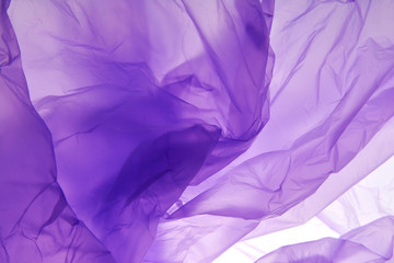 Plastic bag. Luminescent. An experiment with plastic and light. Wonderful purple colors. Abstract background.